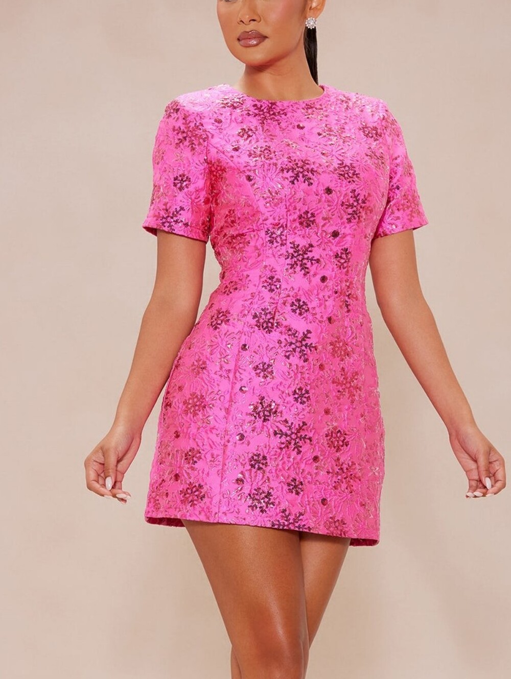 A bright pink mini dress made of textured fabric that is perfect for cocktail